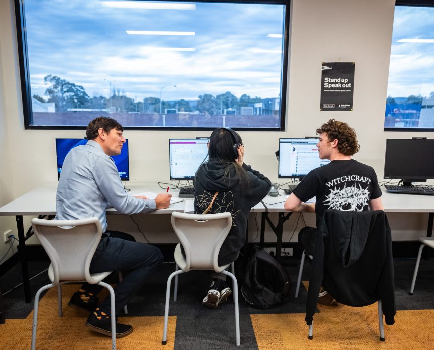 Teacher and two students at desks