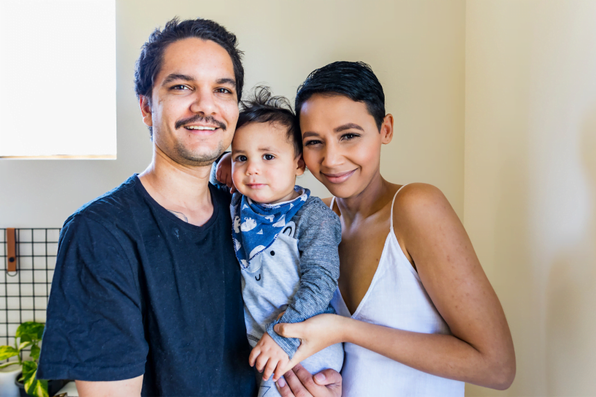 Aboriginal parents hugging toddler
