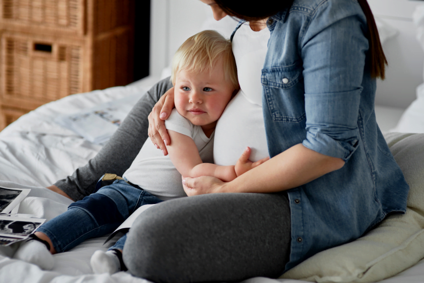 Toddler hugging pregnant mother
