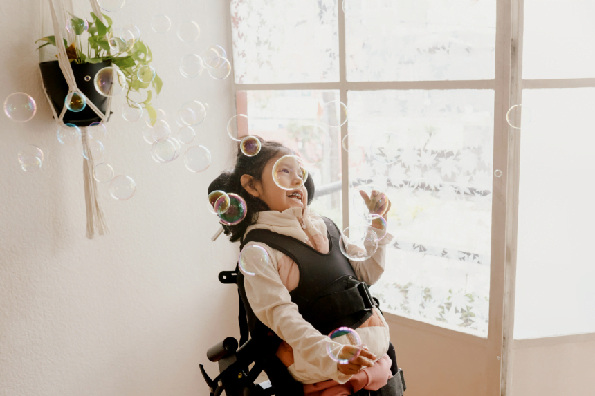 Young girl in wheelchair happy with bubbles
