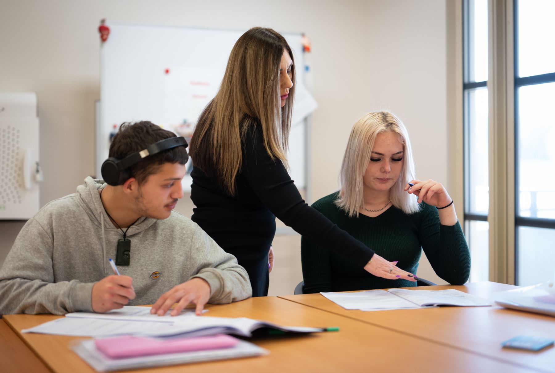 Woman teaching two students