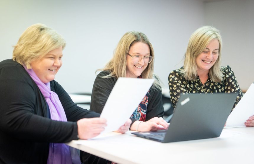 Three women working and laughing