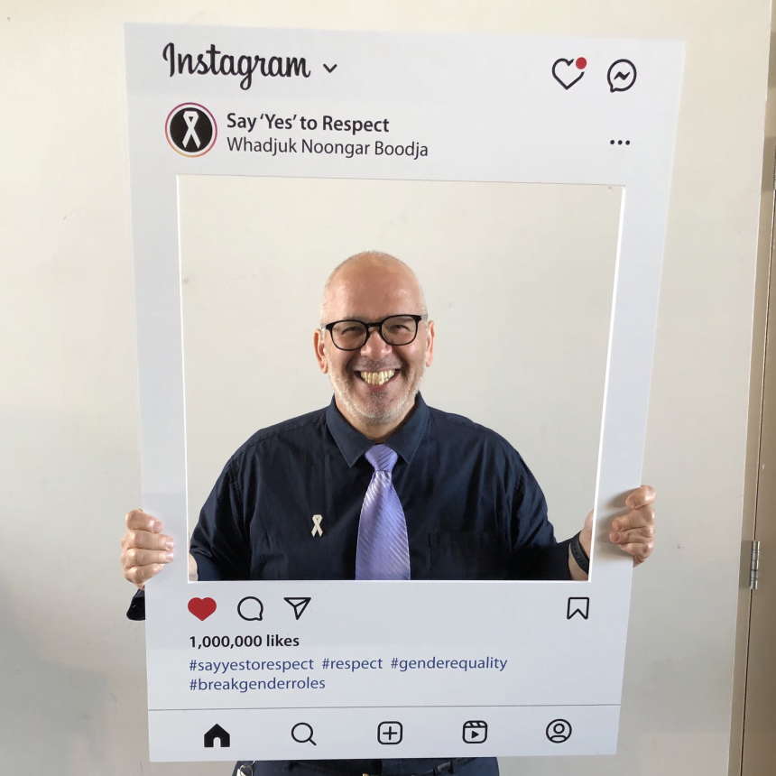 Man smiling holding social media frame